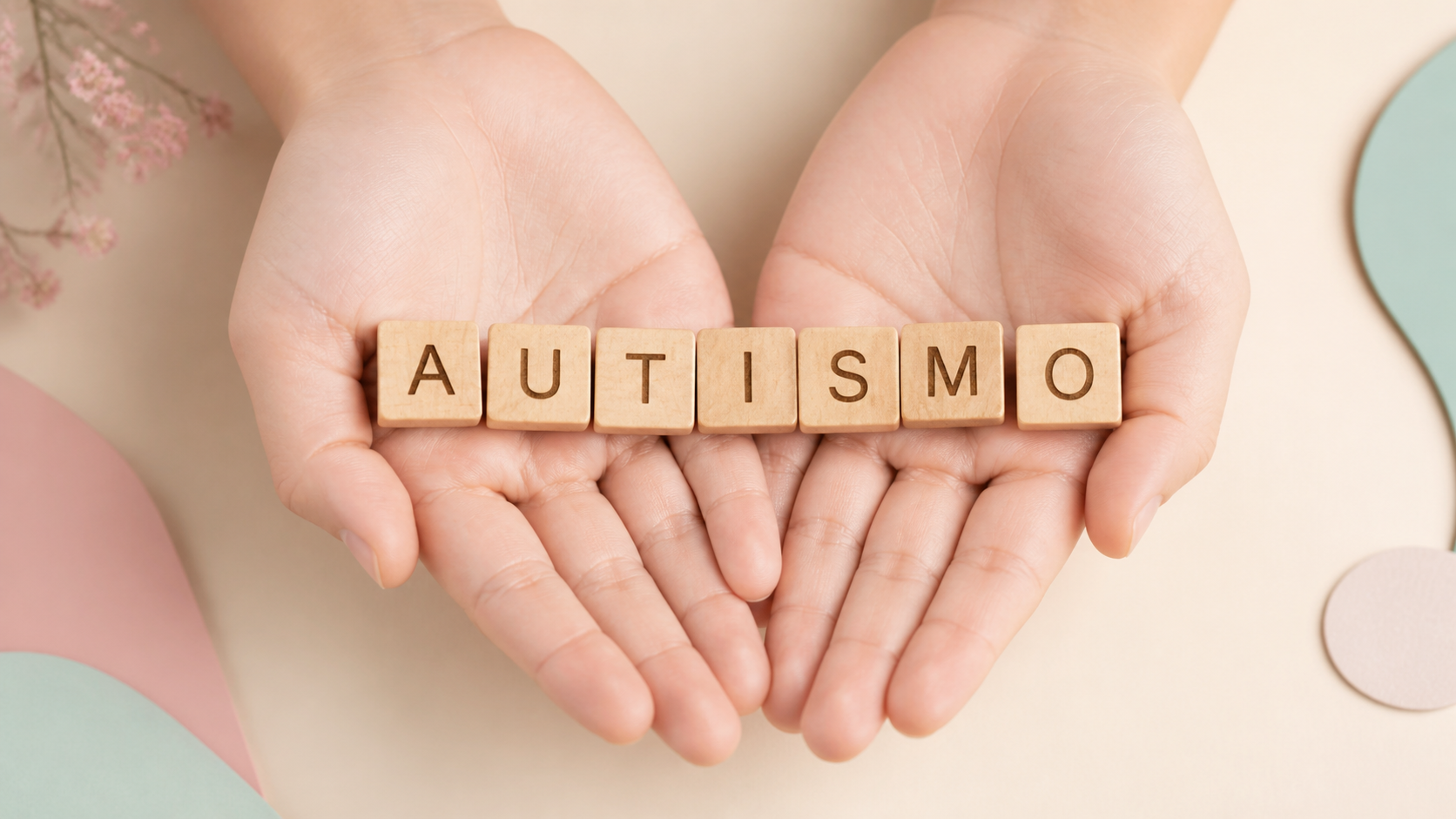 Mãos acolhendo blocos com a palavra autismo